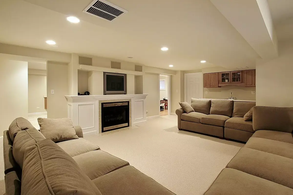 Finished basement family room with recessed lights, a fireplace wall and a small kitchenette